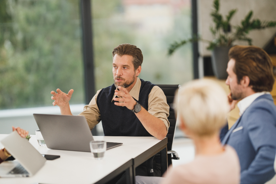 Equipo de negocios reunido alrededor de una mesa, donde las habilidades de español de negocios construyen relaciones con clientes