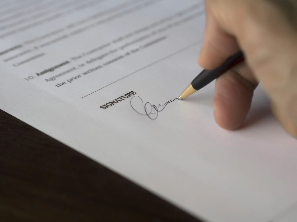 Procurement manager signing a corporate language training RFP document at a desk